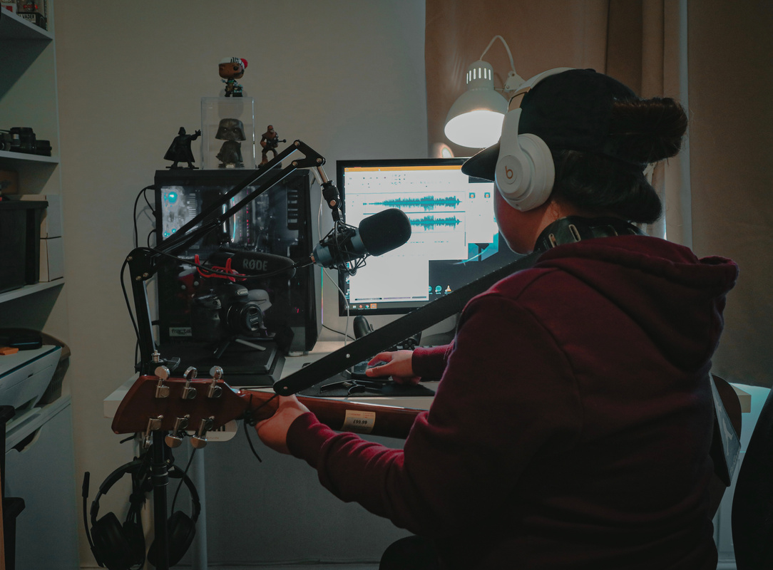 Unrecognizable guitarist recording music at home studio